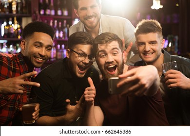 Happy Male Friends Taking Selfie And Drinking Beer At Bar Or Pub