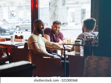 Happy Male Friends Talking In Beer Pub