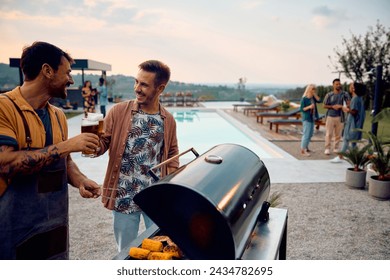 Happy male friends toasting with beer while having BBQ party with fiends by the pool. Copy space. - Powered by Shutterstock