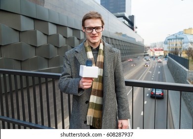 A Happy Male Reporter Leads A Report On The Camera On The Street.