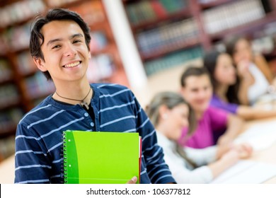 Happy male student smiling with a group at the background