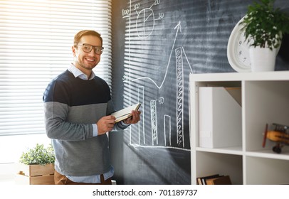 Happy male student, teacher, freelancer with chalk at the blackboard - Shutterstock ID 701189737