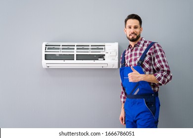 Happy Male Technician Gesturing Thumb Up Near Air Conditioner