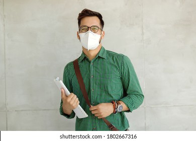 Happy Male University Student Wearing Protective Face Mask While Standing Against The Wall. 