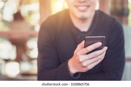 Happy male using smartphone at modern coffee shop, he chatting Online Messaging on mobile phone. - Shutterstock ID 1028865706