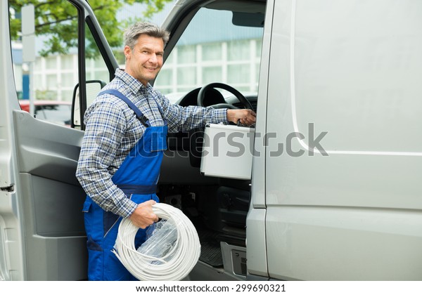 Happy Male Worker With Toolbox And Cable Coil\
Entering In Van