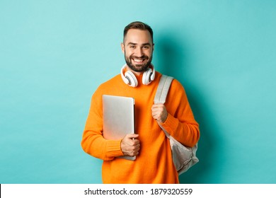 Happy Man With Backpack And Headphones, Holding Laptop And Smiling, Going To Work, Standing Over Turquoise Background