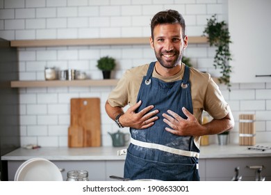 Happy man baking in the kitchen. Man making fresh pasta.