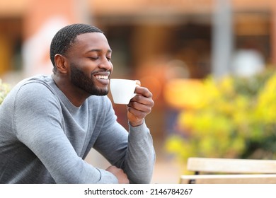 Happy man with black skin drinking coffee smiling in a bar terrace - Powered by Shutterstock