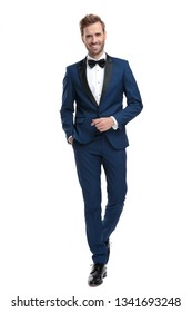 Happy Man In Blue Tuxedo Walking With Hand In Pocket On White Background