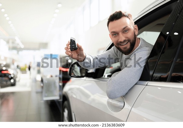 happy man bought a car in a car dealership and\
insurance for it