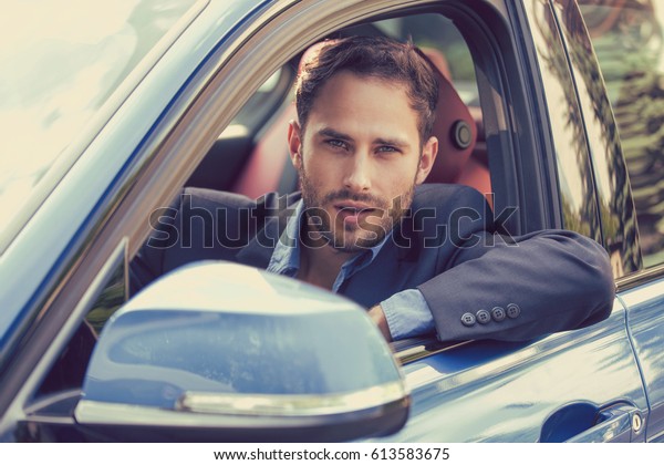 Happy man buyer\
sitting in his new car ready for trip. Personal transportation auto\
purchase concept