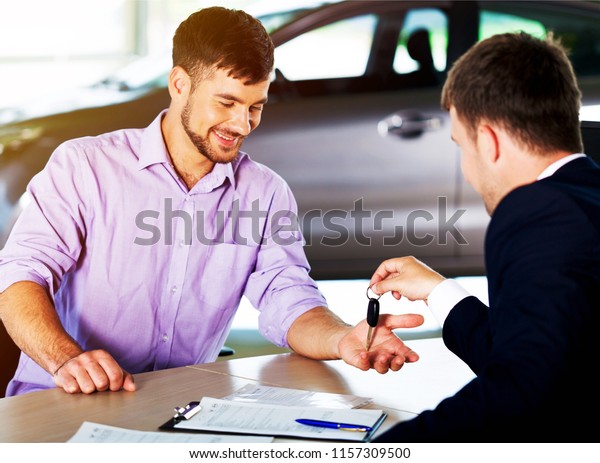 Happy man with car dealer in\
auto