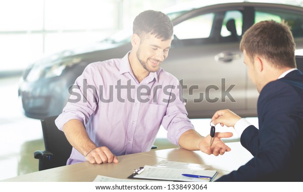Happy man with\
car dealer in auto show or\
salon