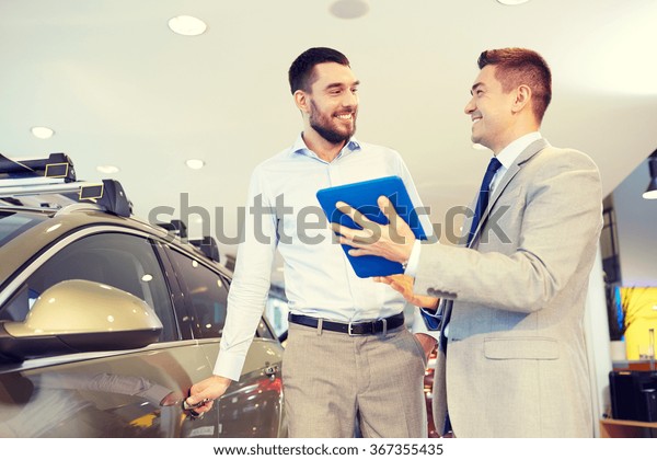 happy man with\
car dealer in auto show or\
salon