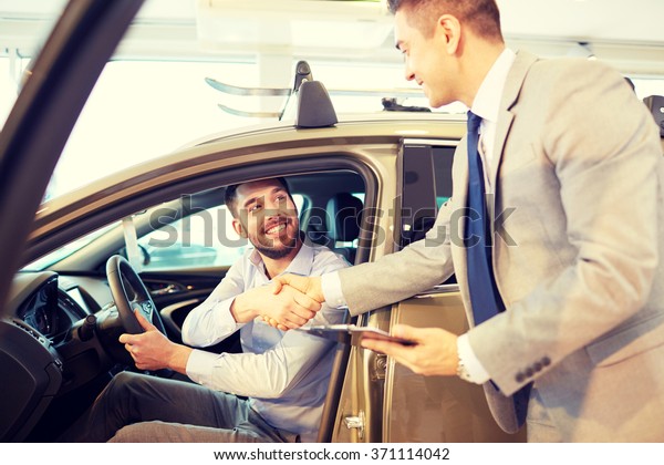 happy man with
car dealer in auto show or
salon
