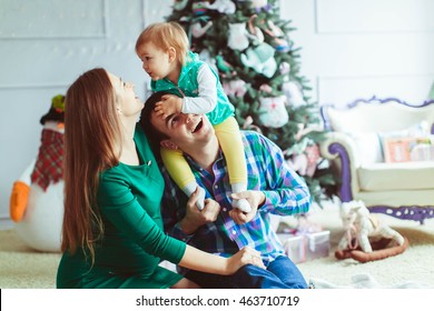 happy man  celebrating Christmas with his wife and daughter