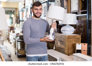 Happy Man Choosing Vintage Table Lamp In Shop Of Secondhand Furniture