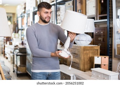 Happy Man Choosing Vintage Table Lamp In Shop Of Secondhand Furniture