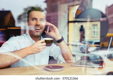 Happy Man At Coffee Shop Talking On The Phone