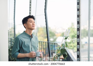 happy man contemplating views with coffee cup on a balcony  - Powered by Shutterstock