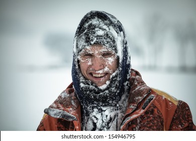 Happy man covered by snow enjoying winter.