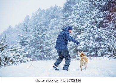 Happy Man With Dog Plays In Snowy Forest In Winter