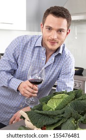 Happy Man Drinking Wine In The Kitchen