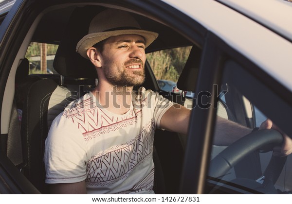 Happy man driving car on summer vacation. Car\
rental and holiday drive\
concept