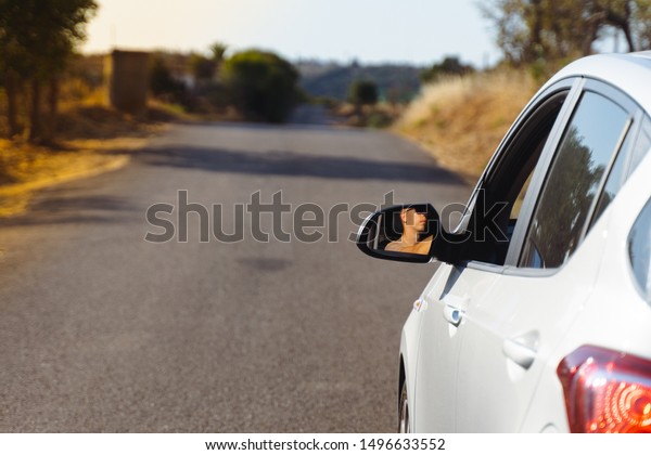 happy man driving a car. traveler enjoying\
road trip. car on asphalt road in nature or the highway. travel by\
car concept. view from back.\
copyspace.