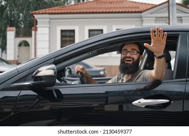 Happy Man Driving A Car And Waving Through The Opened Window, Saying Hello. City Positive People