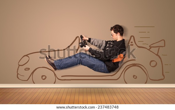 Happy
man driving an hand drawn car on the wall
concept