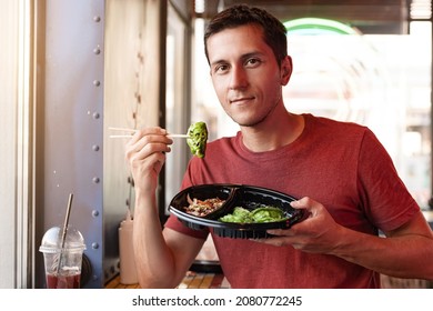 Happy Man Eating Asian Japanese Dumplings Jiaozi In Fastfood Restaurant Near The Window