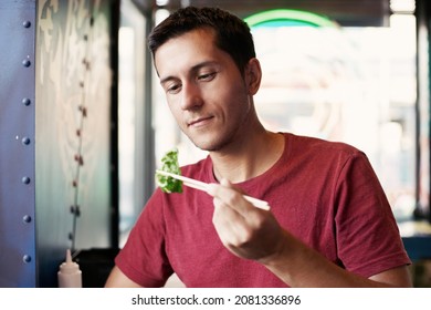 Happy Man Eating Asian Japanese Dumplings Jiaozi In Fastfood Restaurant Near The Window