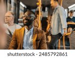 Happy man enjoying his commute on a city bus surrounded by other passengers.