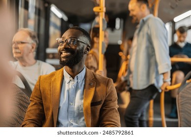 Happy man enjoying his commute on a city bus surrounded by other passengers. - Powered by Shutterstock