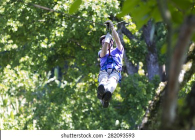 Happy Man Enjoying Zipline Adventure In The Forest - Powered by Shutterstock