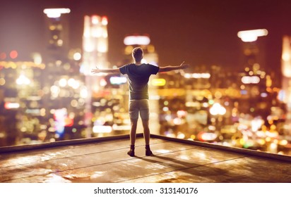 Happy man faces skyline at night