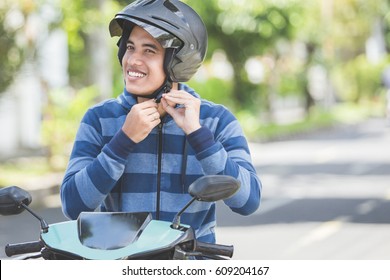 Happy Man Fastening His Motorbike Helmet In The City Street