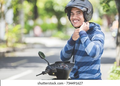 Happy Man Fastening His Motorbike Helmet In The City Street