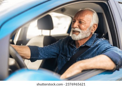 Happy man feeling comfortable sitting on driver seat in his new car. Smiling mature businessman with seat belt on driving vehicle for transport and copy space. - Powered by Shutterstock