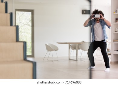 happy man getting experience using VR-headset glasses of virtual reality at home