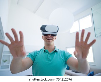 happy man getting experience using VR-headset glasses of virtual reality at home