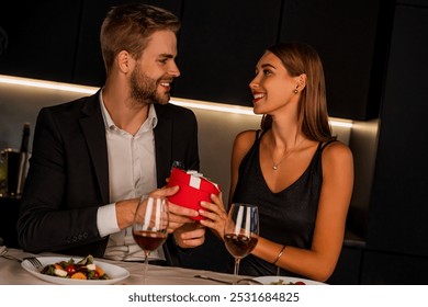 Happy man giving surprise valentine's day present to his girlfriend. Romantic dinner and love relationship. Proposal and marriage. Anniversary celebration - Powered by Shutterstock