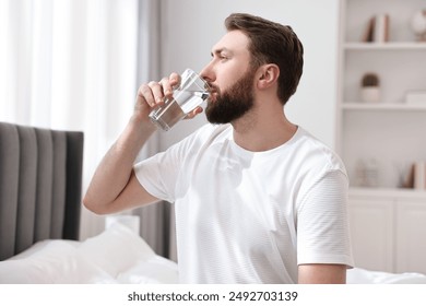 Happy man with glass of water on bed at morning - Powered by Shutterstock