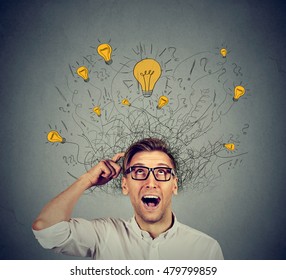 Happy man in glasses looking up with light idea bulb above head isolated on gray wall background - Shutterstock ID 479799859