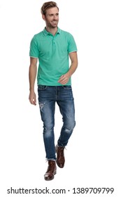 Happy Man In Green Polo Shirt Walking And Looking Away On White Background