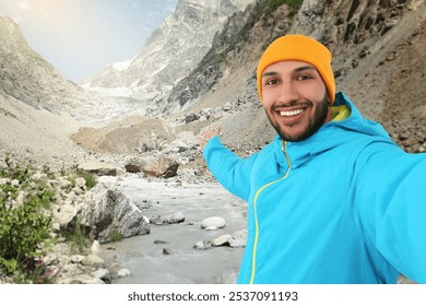 Happy man in hat taking selfie in mountains - Powered by Shutterstock