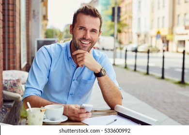 Happy Man Having Coffee Break At Outdoors Cafe During Nice Summer Day