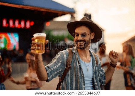 Happy man having fun and dancing at summer music festival. 